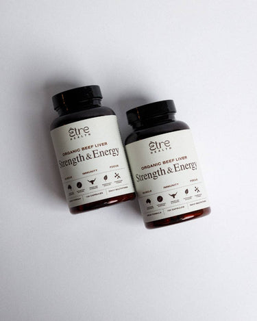 Two bottles of 'Strength & Energy' organic beef liver supplement on a light gray background